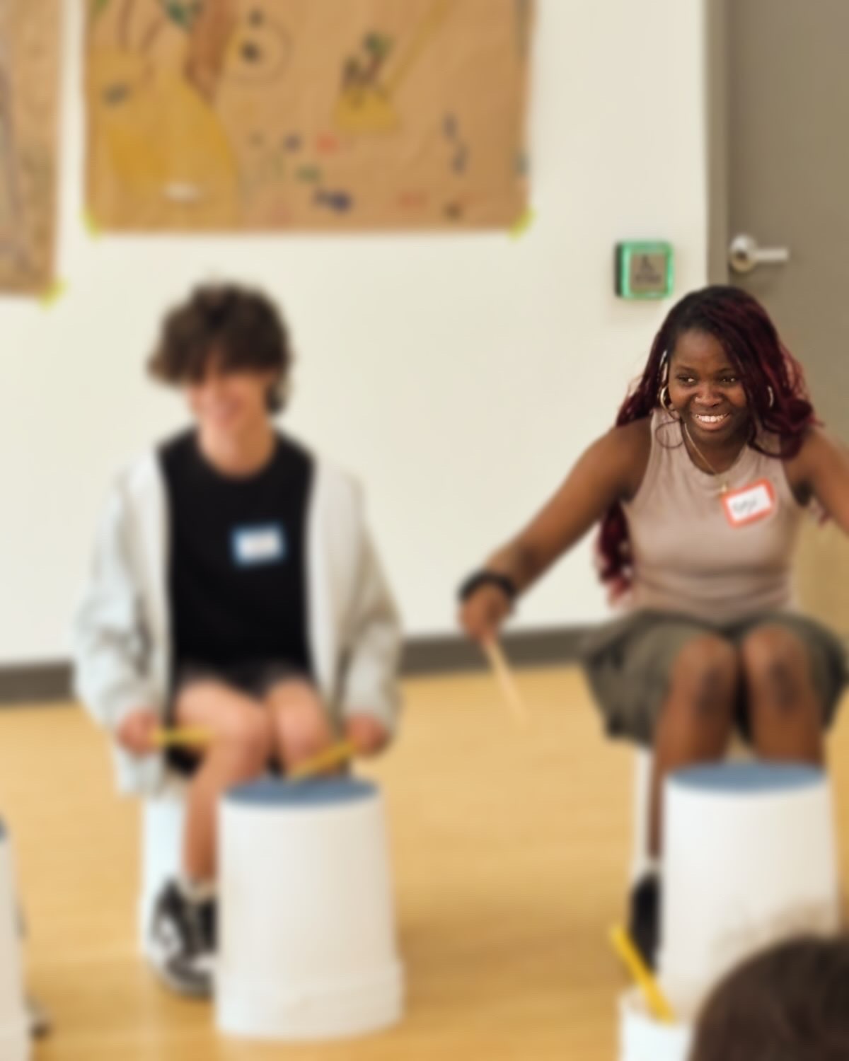 Two participants huddled together during a drumming session.
